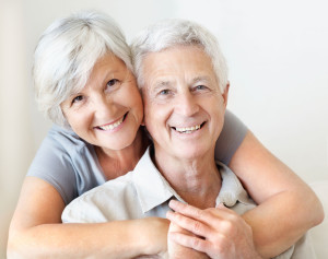 Portrait of a smiling senior couple embracing while sitting at home