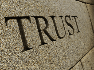 The word TRUST carved into a stone wall. 3D render with HDRI lighting and raytraced textures.