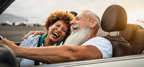 Two elderly couples, smiling and enjoying the scenic drive on a motorway. The image evokes a sense of freedom, retirement, and future planning, suggesting the importance of estate planning for a secure future.