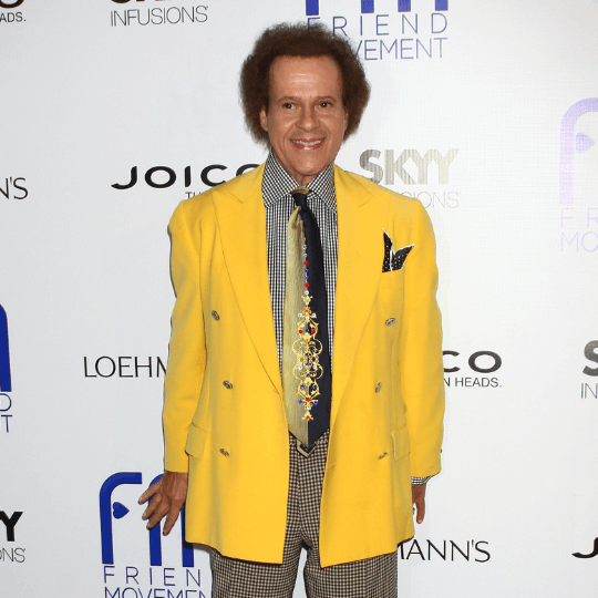 Richard Simmons posing on the red carpet, representing his legacy and estate dispute.