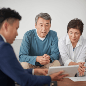 An older couple in Dallas reviewing Power of Attorney documents on a tablet with an Elder Law professional to plan for future capacity.