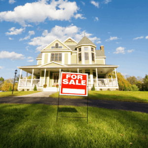 A large house with a 'For Sale' sign, used to represent the importance of protecting a Texas homestead through a qualifying trust or Lady Bird Deed in Dallas.